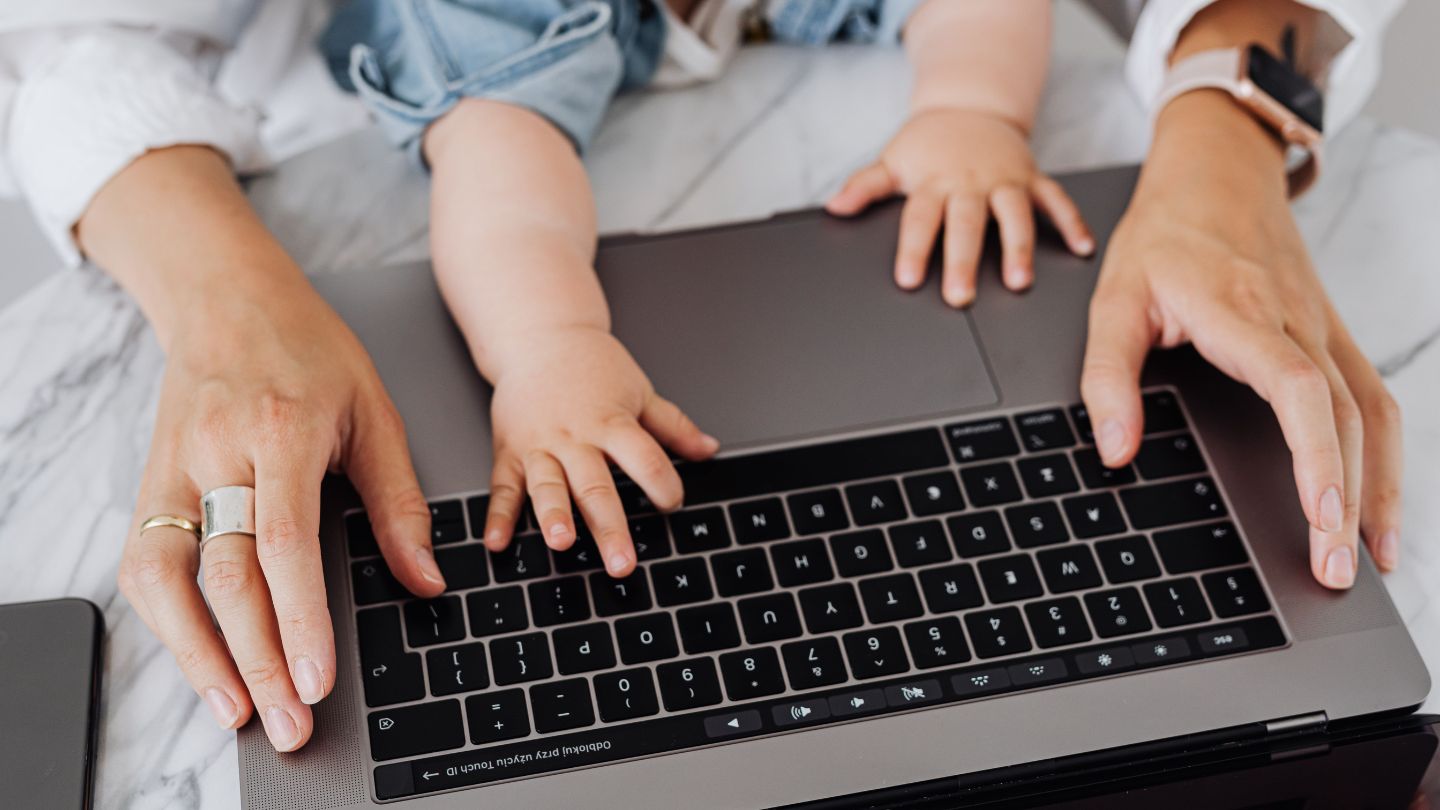 woman trying to work with her baby