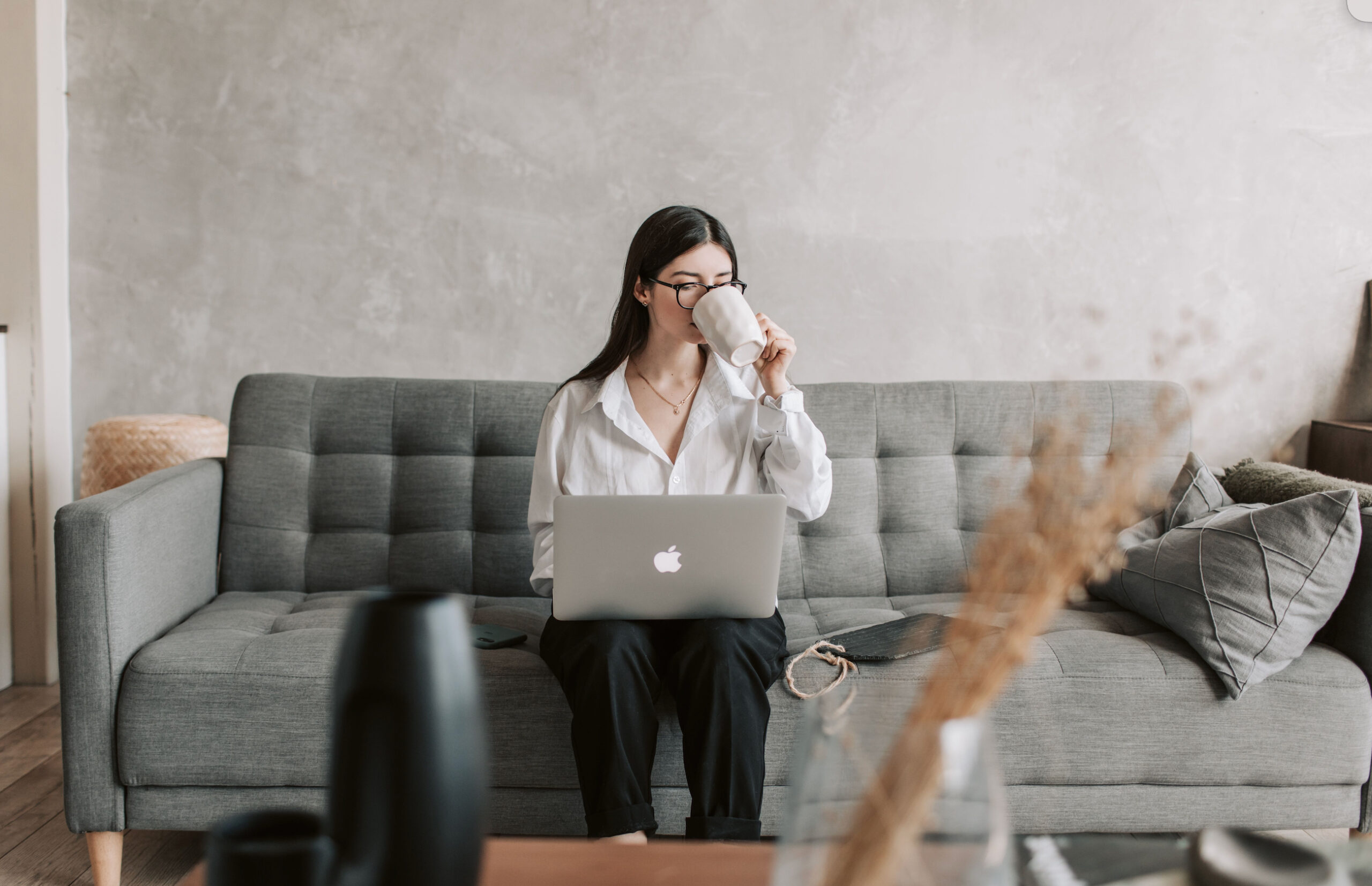 Woman working from home with laptop and coffee