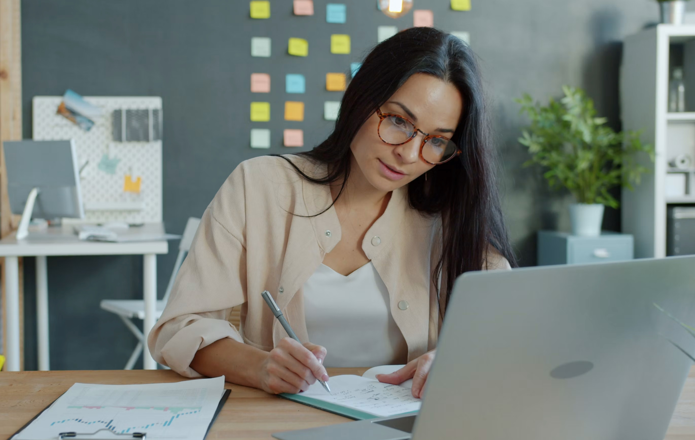 Business owner organizing business systems and processes with laptop and notes